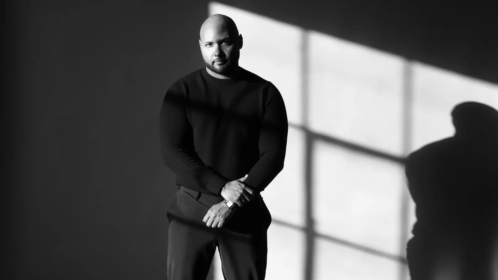 Jonathan Rivera, Founder & CEO of Fan Bridge Media, in a black-and-white portrait by a window